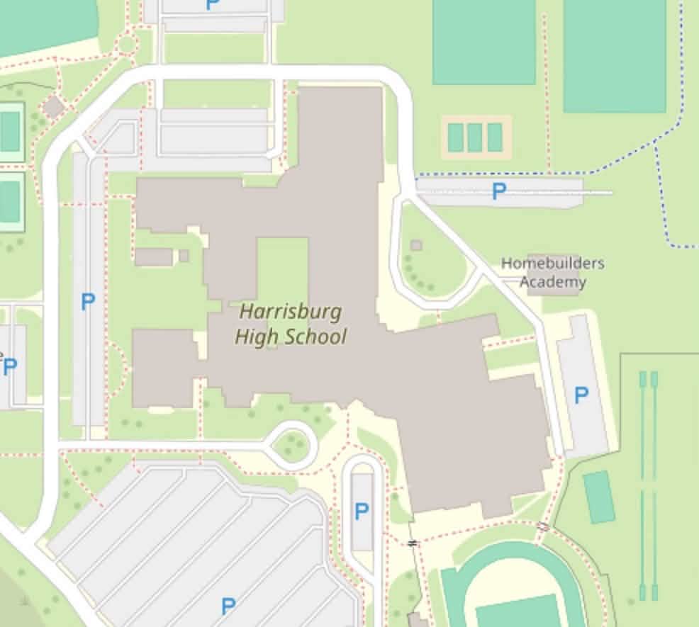 A screenshot of a high school on OpenStreetMap. The building outline is more detailed and fully connected. The road cutting through where the building should be is not present on the map.